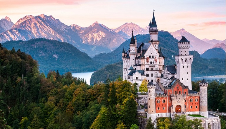 A lush alpine landscape surrounds Germany’s iconic Neuschwanstein Castle.