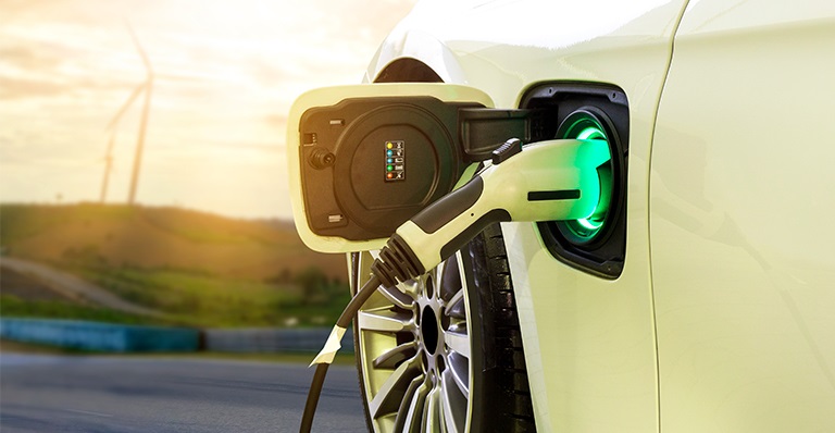 An electric car plugged in at the charging station. 