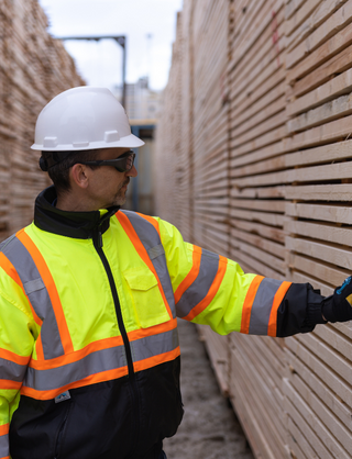 Al Balisky, président et chef de la direction de Meadow Lake Tribal Industrial Investments, inspecte des piles de produits de bois finis.