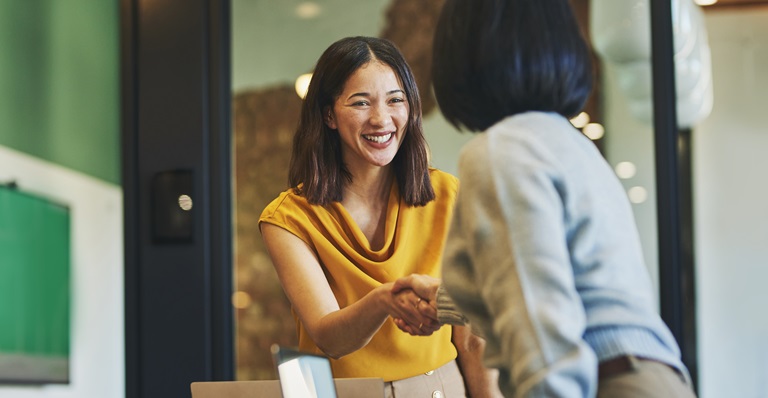 Asian business woman shaking hands with a client.