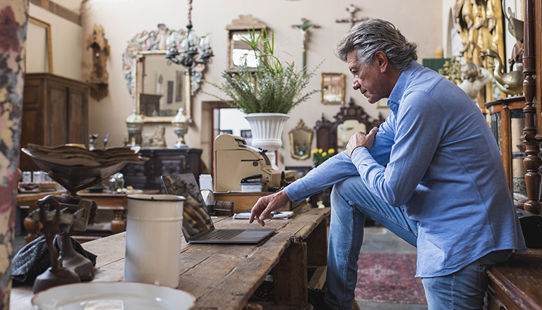 A person sitting on a table looking at a computer