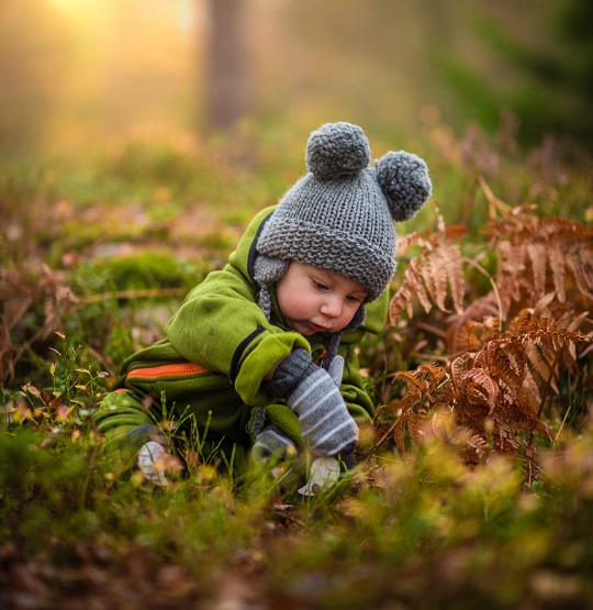 A child wears the finished wool product, a hat with pompom ears.