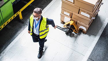 Man pulling boxes on pallet jack