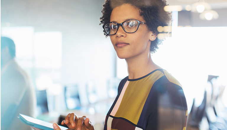 Businesswoman using her tablet while working in her office