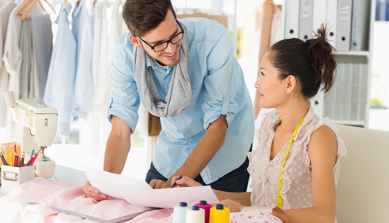Male, female fashion designers work in studio