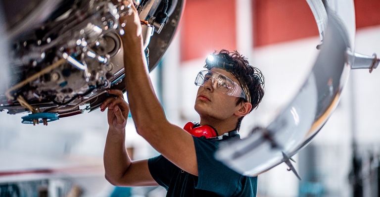 Aircraft mechanic checks engine.