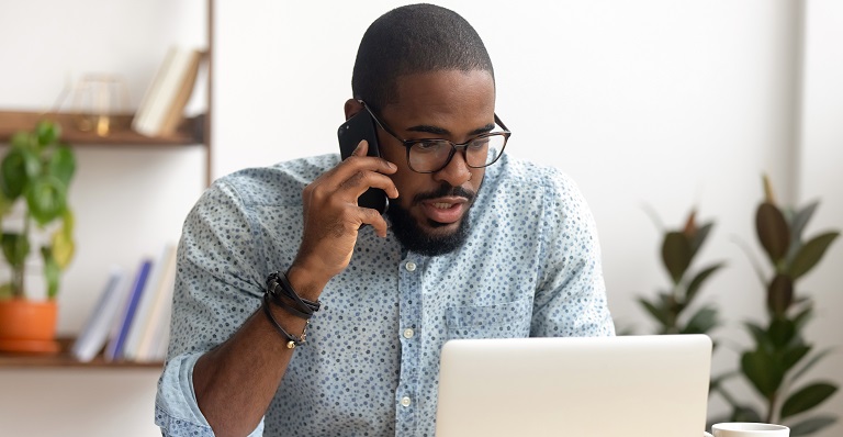 African Canadian businessman on phone at home office