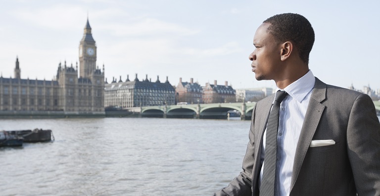African-Canadian business man looks out over the River Thames.