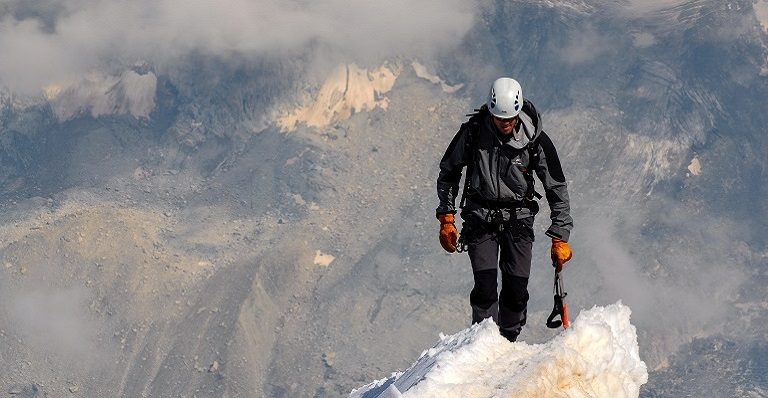 Male climber tackles dangerous snowy mountaintop