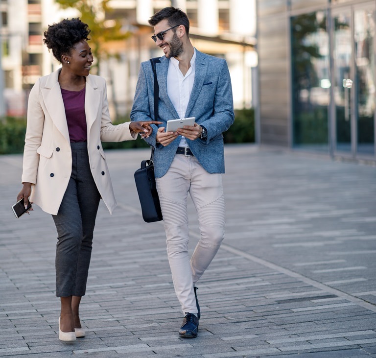 Caucasian businessman, female African American exporter walk to meeting