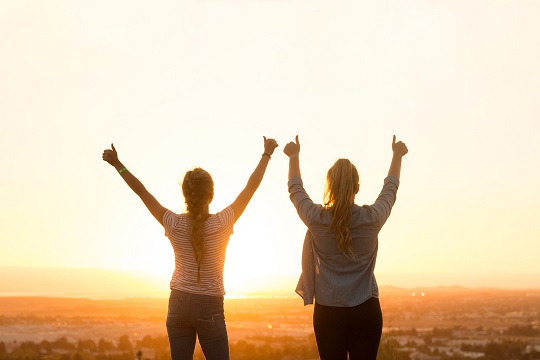 Deux jeunes femmes donnant un pouce en l’air au ciel