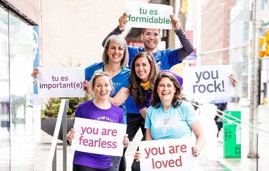 Happy EDC employees hold signs promoting respect