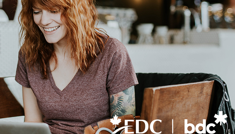 Installée dans un café, devant son ordinateur portable, une jeune entrepreneure réalise des ventes en ligne.