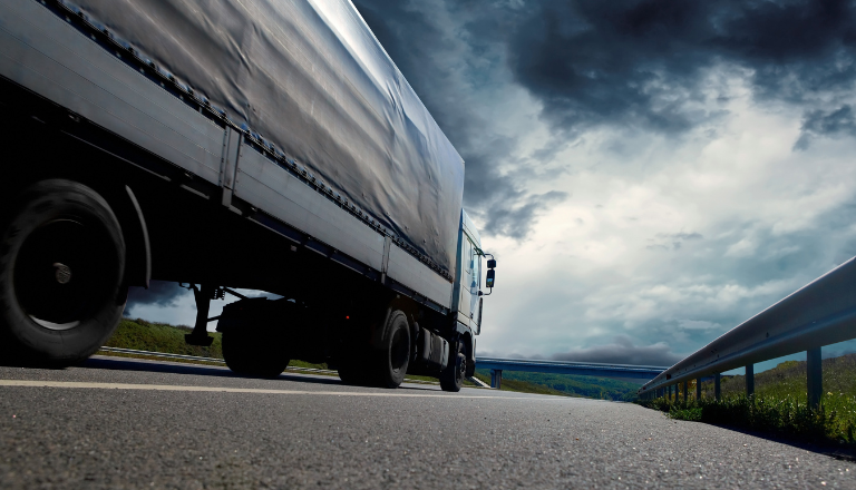 A truck on the road in a cloudy and dark landscape